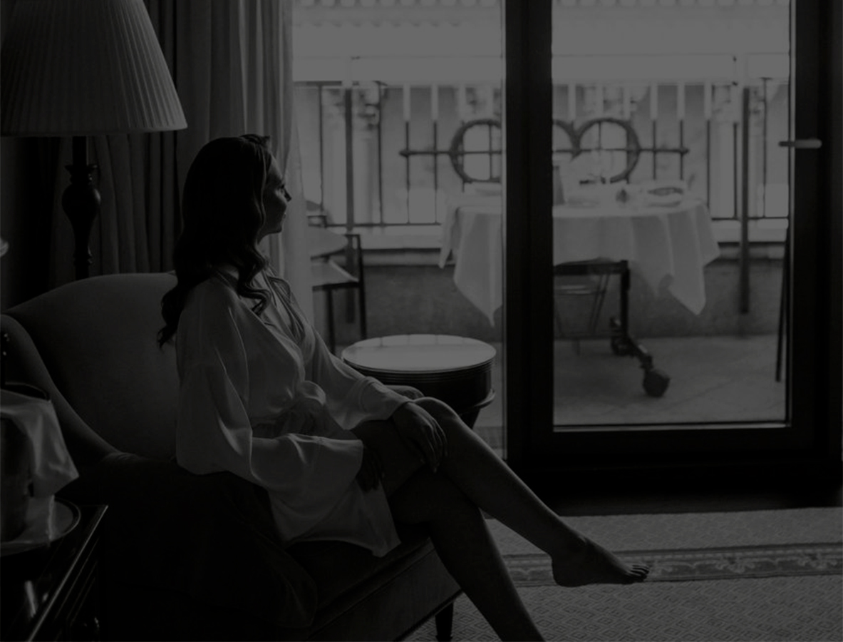 Невеста в номере отеля сидит в кресле в халате