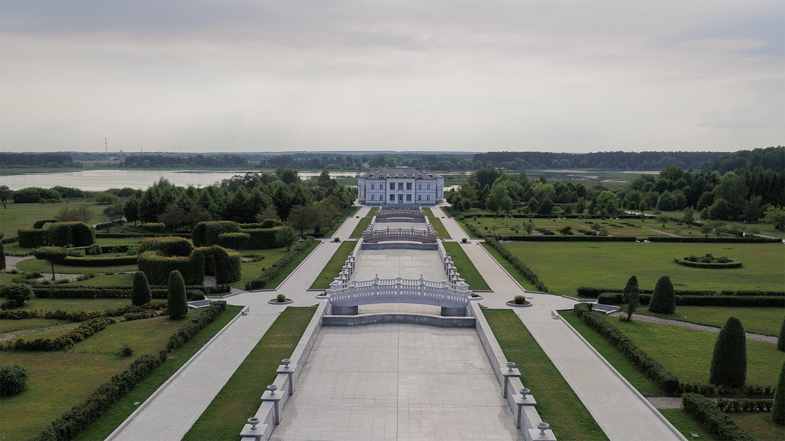 Панорамное фото: по центру вдалеке располагается вилла. За виллой расположены красивые озера. По центру дорожка ведущая к вилле, а по бокам зеленый ухоженный парк