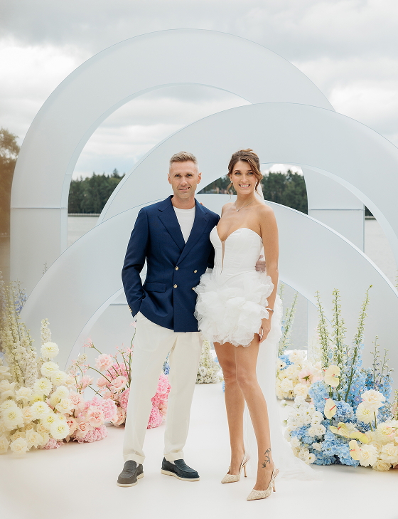 Молодожены на фоне водоема и свадебного декора